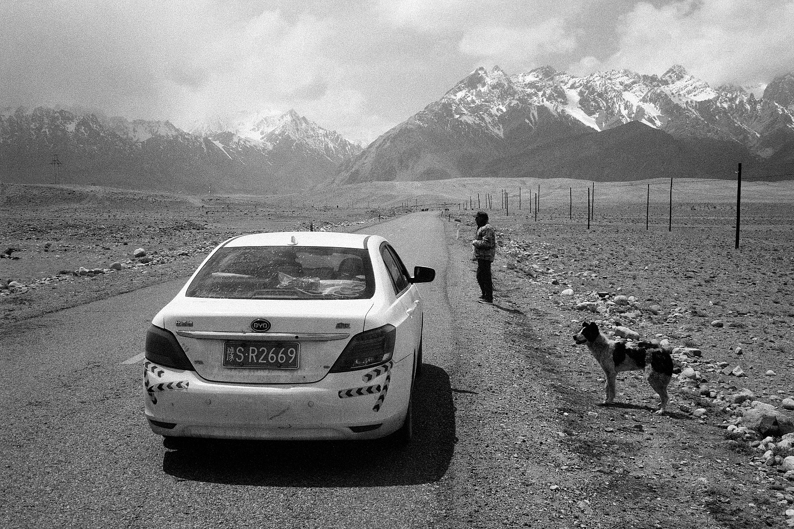A estrada sob as montanhas nevadas e os transeuntes — 富华 · Canon EOS-1N · Ilford Delta 100 Professional